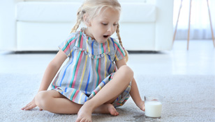child spilling milk on carpet